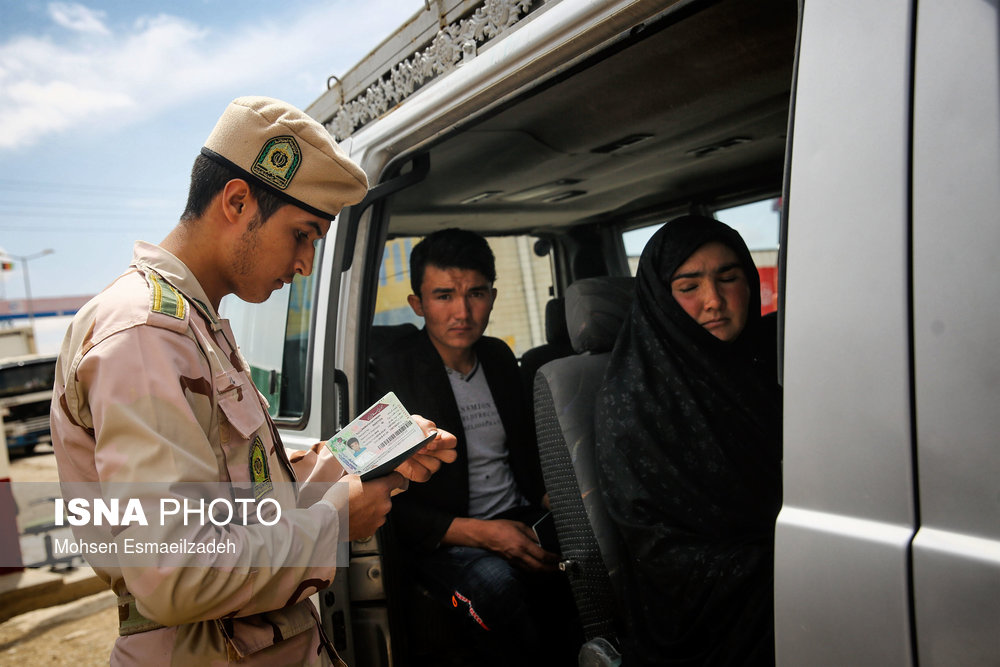 یک سرباز وظیفه مدارک شناسایی مسافران افغان را کنترل می‌کند.