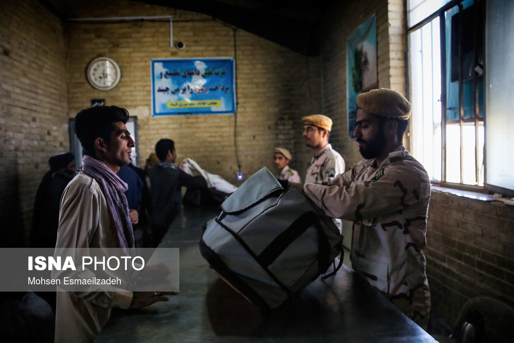 سربازان مرزبانی وسایل مسافران افغان را که از طریق مرز دوغارون وارد کشور شده‌اند بازرسی می‌کنند.
