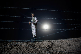 یک سرباز وظیفه در حال نگهبانی شبانه در مرز تایباد است، مرزداران جمهوری اسلامی ایران به صورت شبانه روزی در حال حراست از مرزهای ایران هستند.