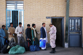 یک سرباز مرزبانی مدارک مسافران افغان را کنترل می‌کند.