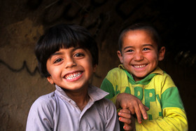 کودک افغان در کنار دوست ایرانی‌اش (در سمت چپ) به بازی مشغولند.