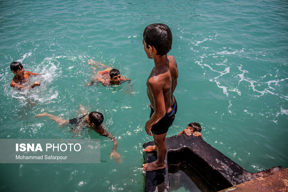 چندین پسر بچه اهل جزیره هرمز در حال شنا و آب تنی در آب‌های خلیج فارس.