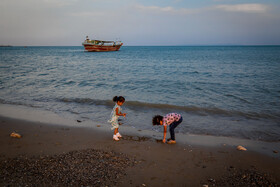 دو کودک در حال بازی با شن‌ها در ساحل بندر عباس.