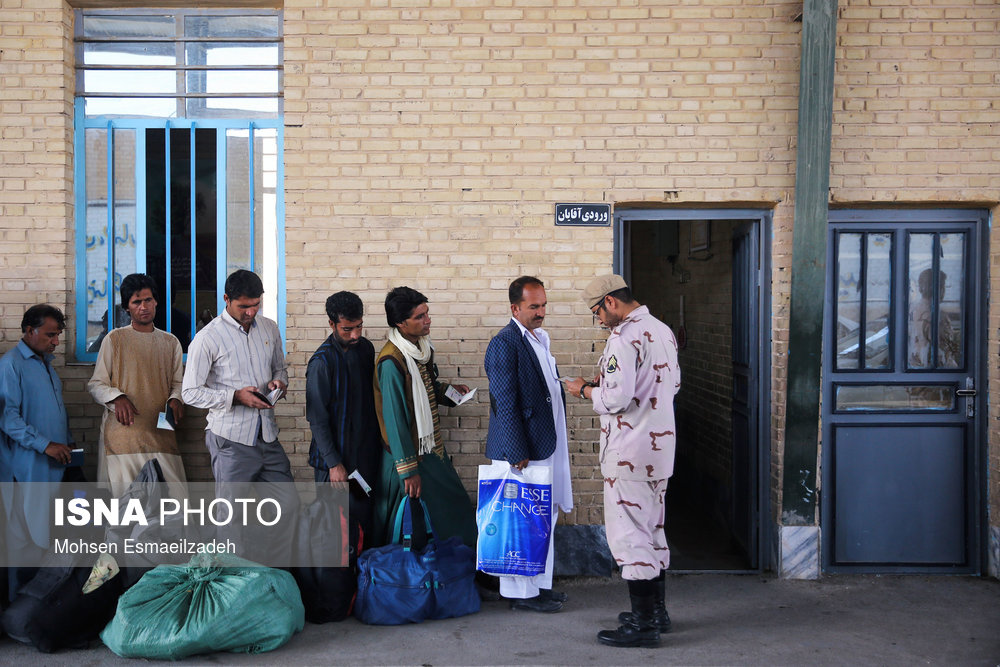 یک سرباز مرزبانی مدارک مسافران افغان را کنترل می‌کند.