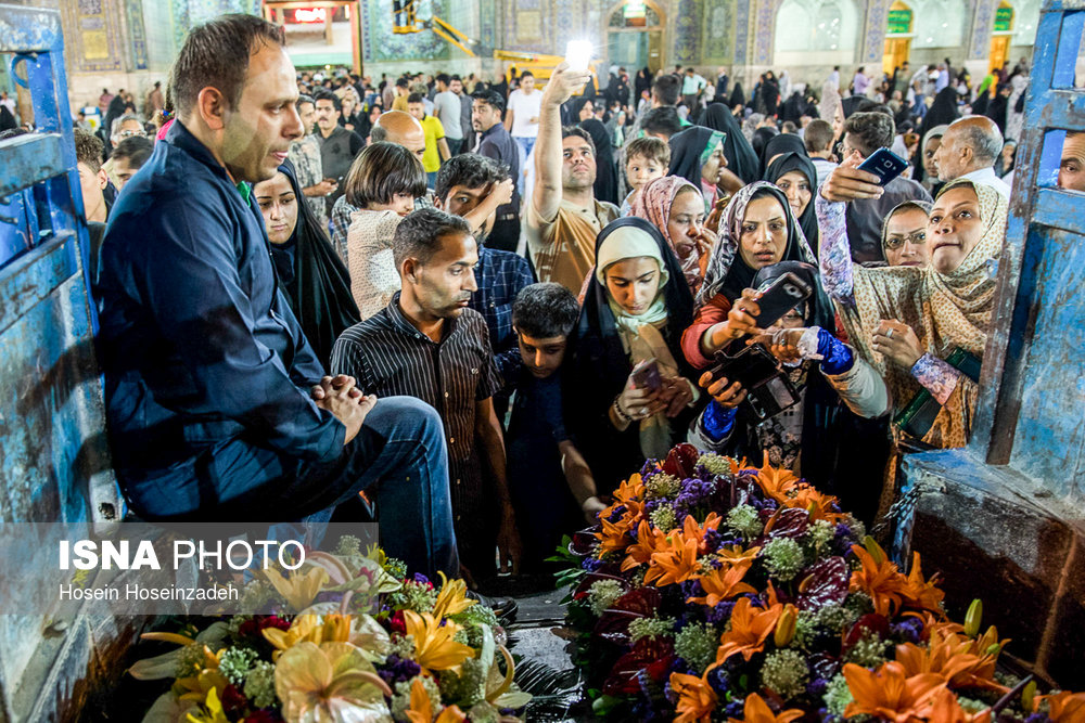 خدام حرم رضوی گل های تزیینی که به مناسبت میلاد امام رضا تعویض شده اند را جهت تبرک به زائران اهدا می کنند.
