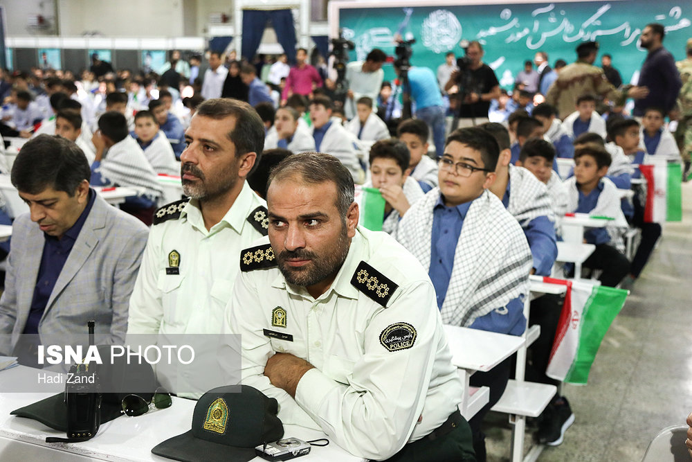 حضور ماموران نیروی انتظامی پشت نیمکت‌ در مراسم نواخته شدن زنگ دانش آموز شهید