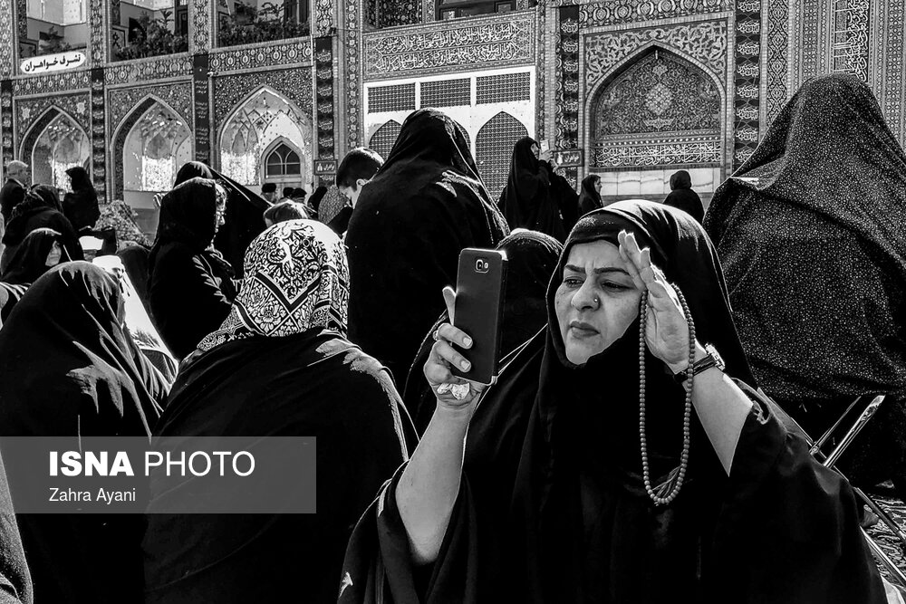 برخی زائران در حرم مطهر رضوی به وسیله تلفن همراه خود با عزیزانشان که در خارج از کشور هستند ارتباط تصویری برقرار می کنند.