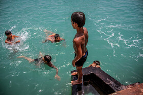 چندین پسر بچه اهل جزیره هرمز در حال شنا و آب تنی در آب‌های خلیج فارس.