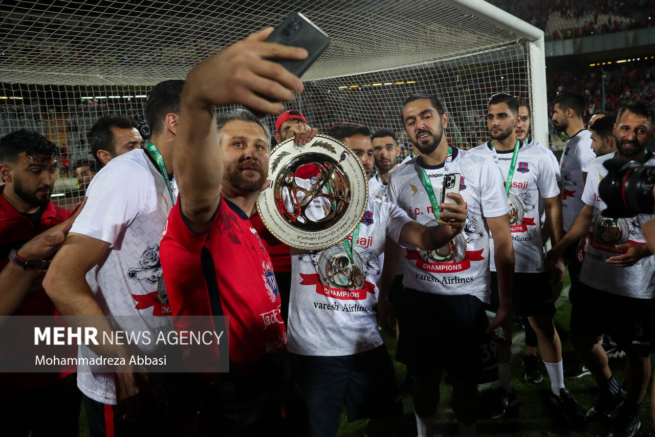 یازیکنان تیم فوتبال نساجی مازندران پس از قهرمانی در جام حذفی در حال گرفتن عکس یادگاری به همراه جام قهرمانی هستند